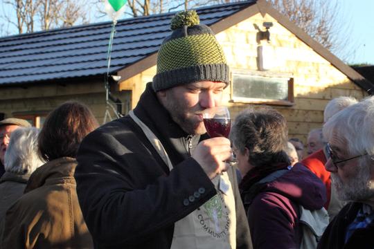 A photo of a Shop volunteer drinking a glass of mulled wine